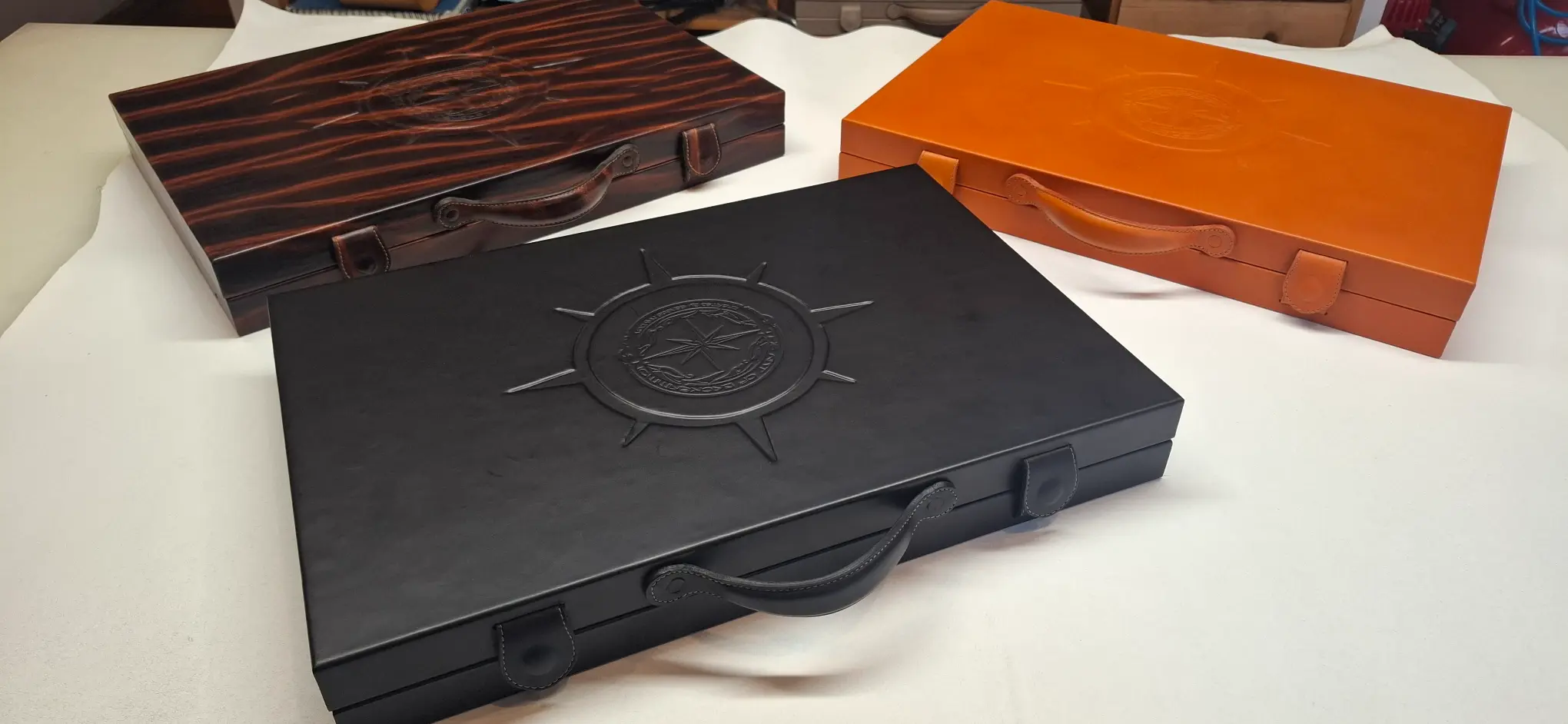 Collection of luxury leather backgammon boards in brown, black, and orange, handcrafted with premium Italian leather.